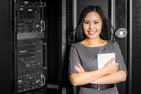 Young engineer businesswoman with tablet in network server roomの写真素材