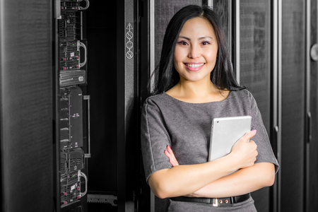Young engineer businesswoman with tablet in network server roomの写真素材