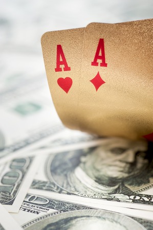 Gold poker cards on money background on a tableの写真素材