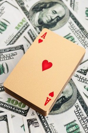 Gold poker cards on money background on a tableの写真素材