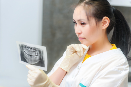Dentist looking at x-ray picture in the officeの写真素材