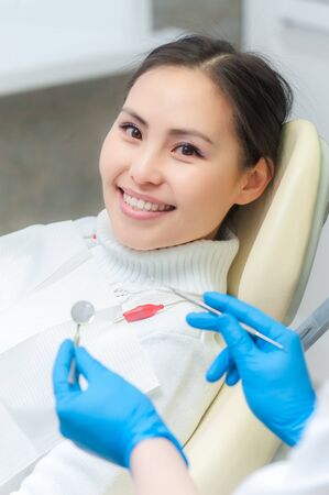 Young female patient at dentist office showing its white smileの写真素材