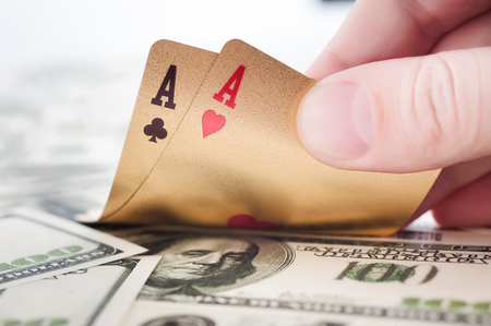 Gold poker cards on money background on a tableの写真素材