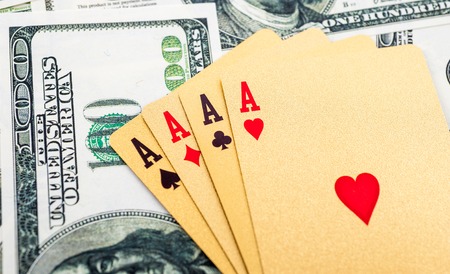 Gold poker cards on money background on a tableの写真素材