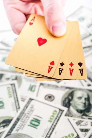 Gold poker cards on money background on a tableの写真素材