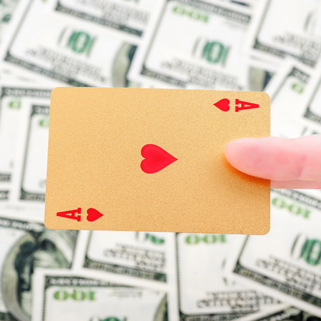 Gold poker cards on money background on a tableの写真素材