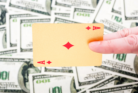 Gold poker cards on money background on a table