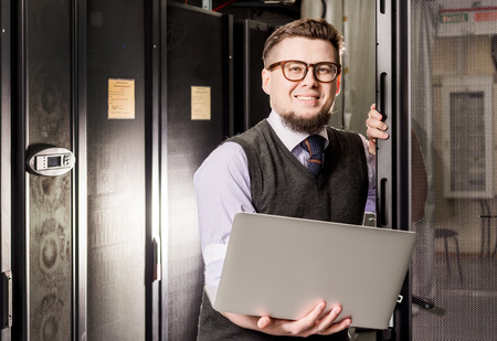Young engineer wearing glasses in a datacenter