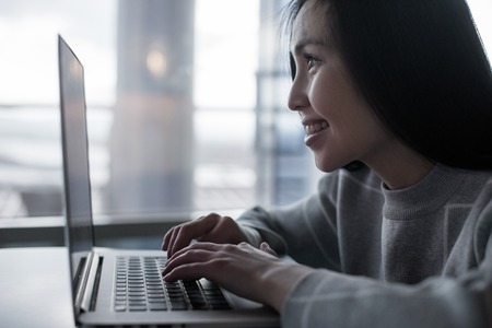 Young beautiful happy asian woman using laptopの写真素材
