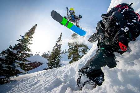Flying snowboarder in the mountains making a trick.の写真素材