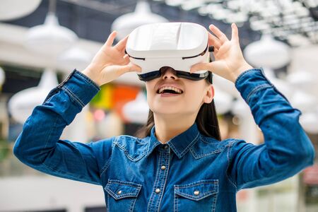 Emotional pretty woman wearing virtual reality glasses