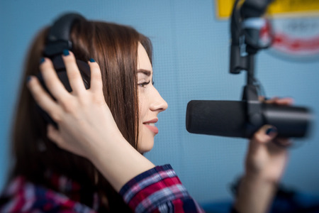 female dj working in front of a microphone on the radioの写真素材