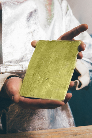 Raw gold ingot in hands just made at a factoryの写真素材