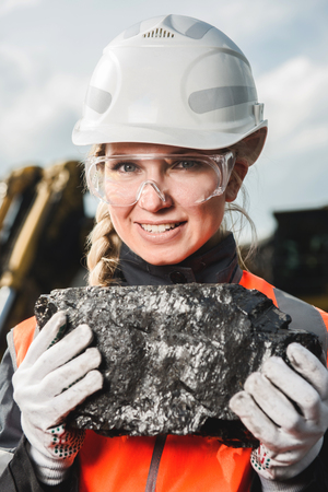 Young beautiful female holding a piece of coalの写真素材
