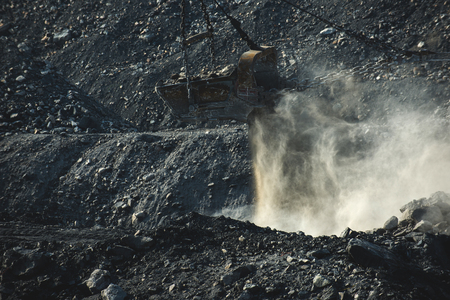 An Excavator bucket on a rocky background.
