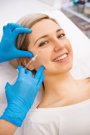 Beautiful woman gets beauty facial injections. Face aging injection. Aesthetic Cosmetologyの写真素材
