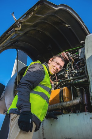 Young male mechanic fixing old airplane's engineの写真素材