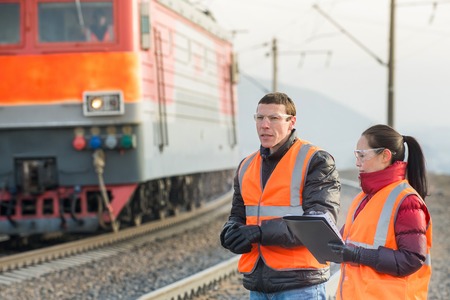 Workers at a railway inspecting train cargosの写真素材
