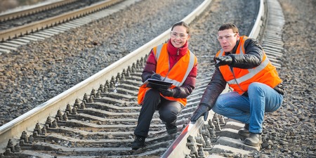 Male and female railroad workers near railways doing their jobの写真素材