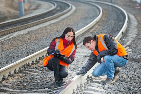 Male and female railroad workers near railways doing their jobの写真素材