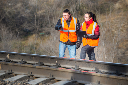 Male and female railroad workers near railways doing their jobの写真素材