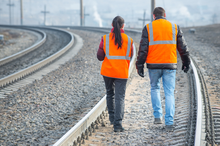 Male and female railroad workers near railways doing their jobの写真素材