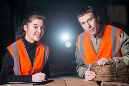Workers with cardbord boxes checking its quality at the factoryの写真素材