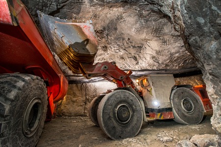 Gold mining underground. Loading truck with golden ore in the tunnel.の写真素材