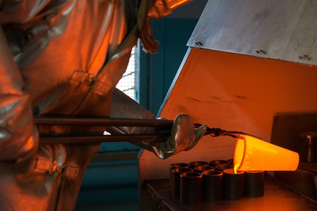 Pouring melted gold in the metal form at a factoryの写真素材