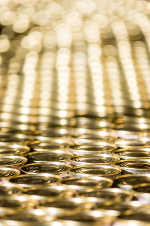 Many golden cans at a factory on a conveyourの写真素材