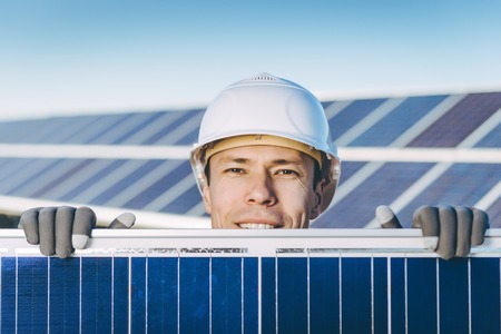 A man at the solar panel of a solar power stationの写真素材