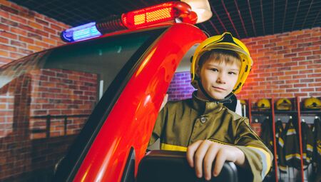 A child in firefighter's uniform playingの写真素材
