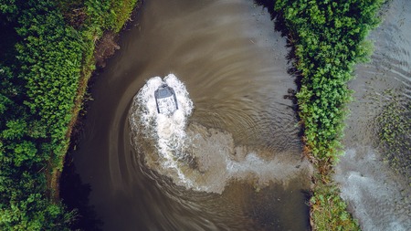 An off-road vehicle sails on the river. aerial above view topの写真素材