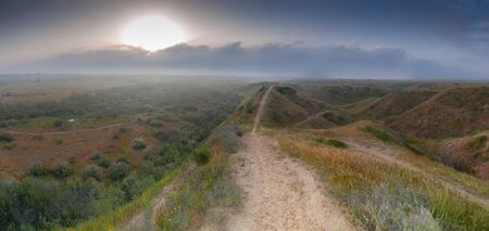 Panoramic veiw of single cycling road at sunrise in the Negev hills near the Gaza border. High resolution panorama taken in the spring seasonの写真素材