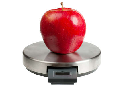 Big red apple on a scales isolated over white background. Diet conceptの写真素材