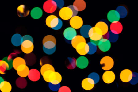 Abstract background with colorful defocused lights over black backgroundの写真素材