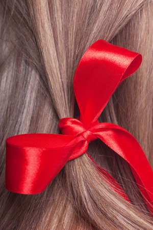 Closeup view of red bow in a womans hairの写真素材