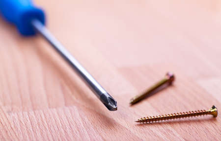 Closeup view of screwdriver over wood background