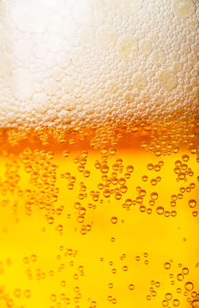 Orange beer and white froth background  Closeup view 