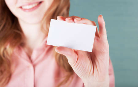 Image of smiling business woman holding her visiting cardの写真素材