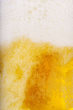 Beer and white froth background. Closeup view.