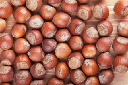 Closeup view of hazelnuts on a wooden tableの写真素材