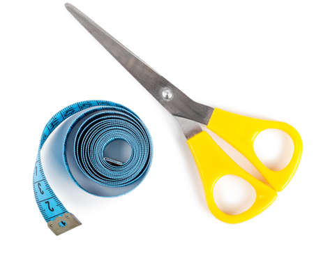 Closeup view of blue measuring tape and scissors over white backgroundの写真素材