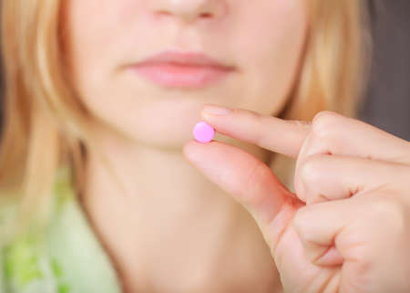Woman taking a pill. Closeup viewの写真素材