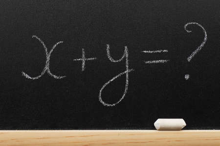 Mathematical equation written on a blackboard by a chalkの写真素材