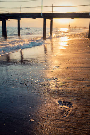 Footprints on the beach in the eveningの写真素材