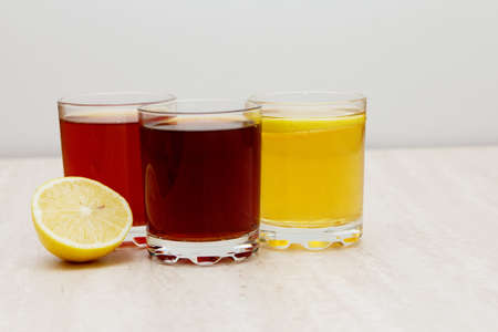 drinks of different colors and texture in glass cups on table on white background. A place for a label. Copyspaceの写真素材
