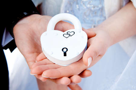 Hands and white lock. Wedding ceremony.   The bride and groom loving couple bonded along their Union. The symbol and concept of eternity, love, beginning, new and old.の写真素材