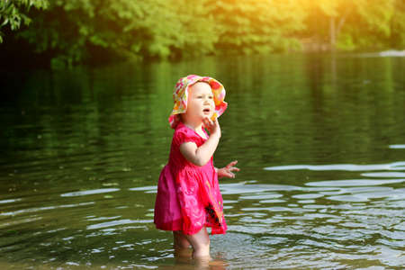 The child bathing in the lake. A little girl in the water. Summer.の写真素材