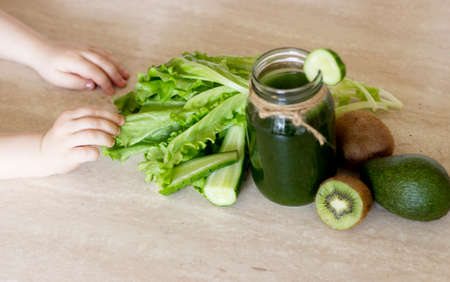 Vegetable smoothies green. The concept of diet, detox, vegetarianism and a healthy lifestyle. Child's hands veganの写真素材